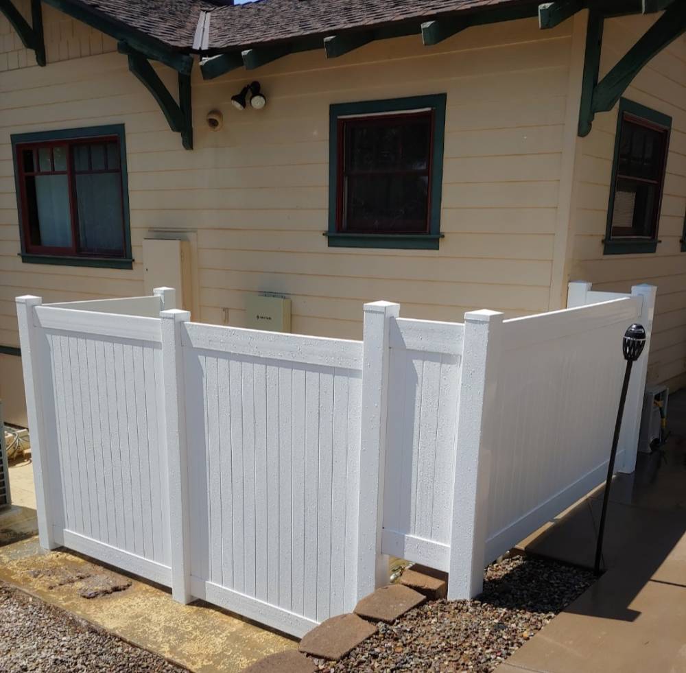White vinyl fence installed around a utility area at a San Diego home